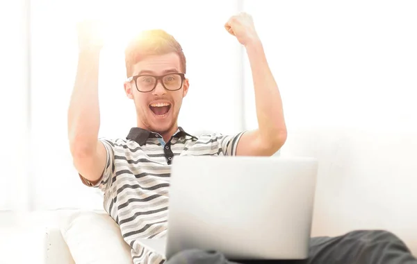 Homem feliz com laptop sentado no sofá — Fotografia de Stock