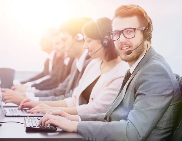 Exploitant callcenter met collega's zitten op de werkplek — Stockfoto