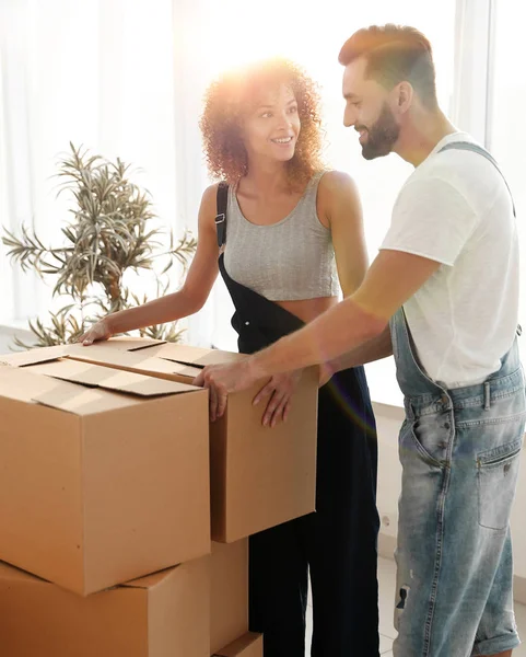 Recién casados llevan cajas en un nuevo apartamento . — Foto de Stock