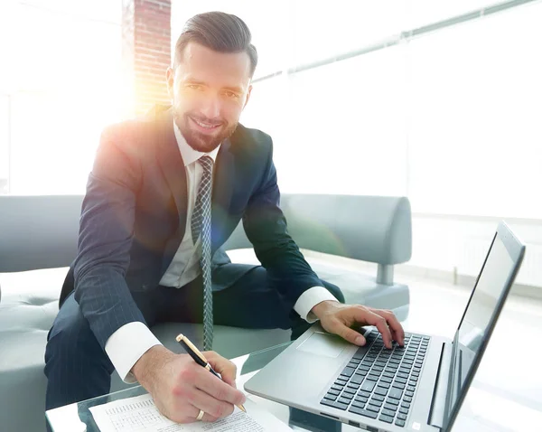 Hombre con estilo que trabaja en el ordenador portátil y toma notas en el cuaderno —  Fotos de Stock