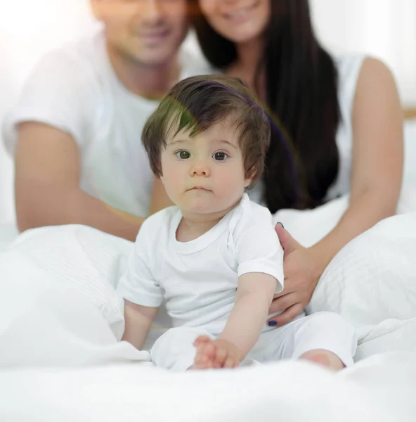 Casal feliz e filho sentado na cama — Fotografia de Stock