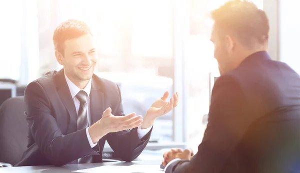 Socios de negocios hablando mientras está sentado en su escritorio — Foto de Stock