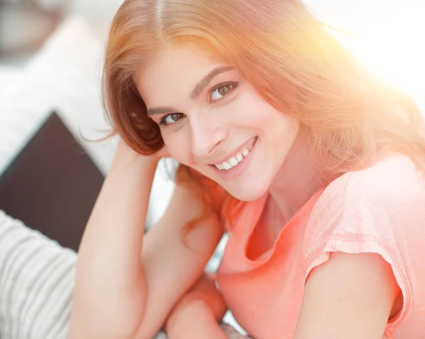 Portret van jonge lachende vrouw op de achtergrond van de woonkamer. — Stockfoto