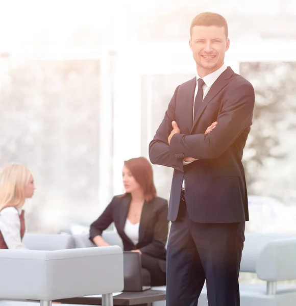 Succesvolle zakenman permanent in de lobby van zijn ambt. — Stockfoto