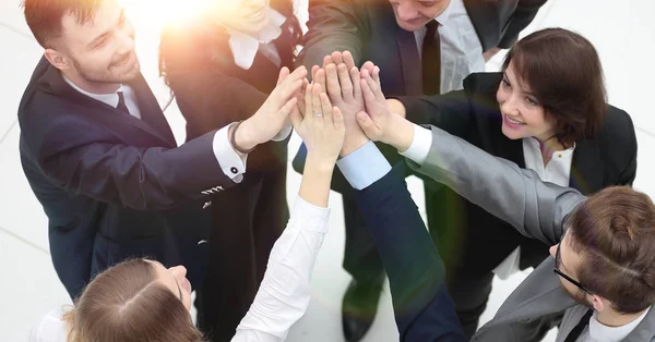 Primer plano. alegre equipo de negocios con las manos cruzadas juntas —  Fotos de Stock