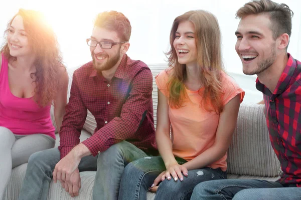 Ομάδα χαμογελώντας νέοι άνθρωποι καθισμένοι στον καναπέ — Φωτογραφία Αρχείου