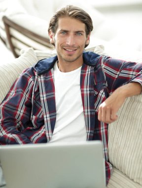 dizüstü bilgisayarda çalışan ve kameraya bakarak başarılı adam. Yukarıdan görüntülemek