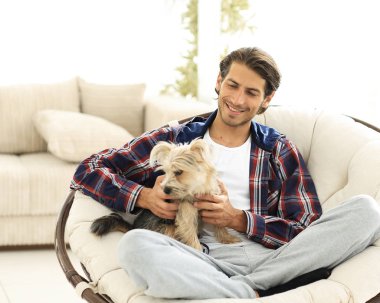 yakışıklı olan büyük bir koltukta oturan bir köpekle.