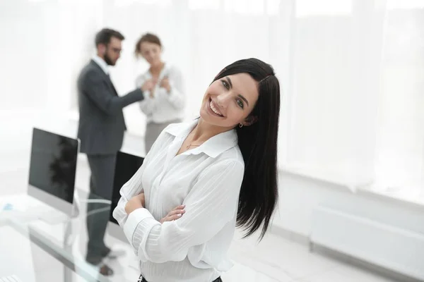 Giovane donna d'affari di successo sullo sfondo di un posto di lavoro — Foto Stock