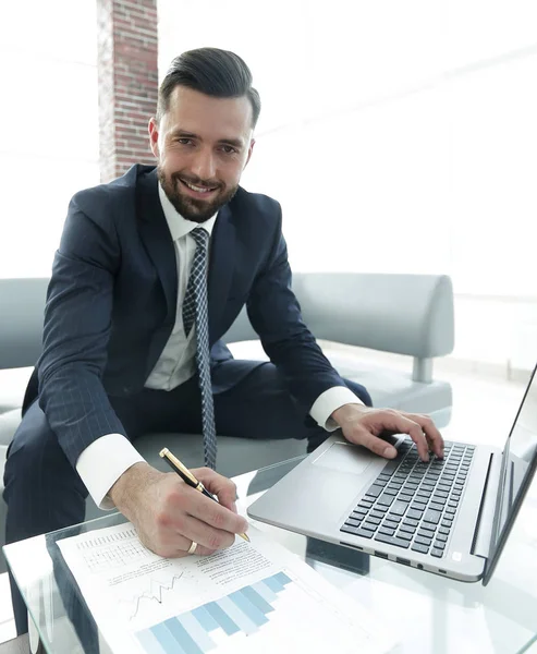 Hombre con estilo que trabaja en el ordenador portátil y toma notas en el cuaderno —  Fotos de Stock