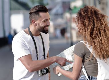 Genç çift mutlu görünürken bir rehbere bakıyor.