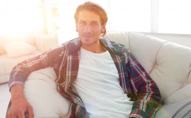 başarılı adam modern oturma odasında dinleniyor.