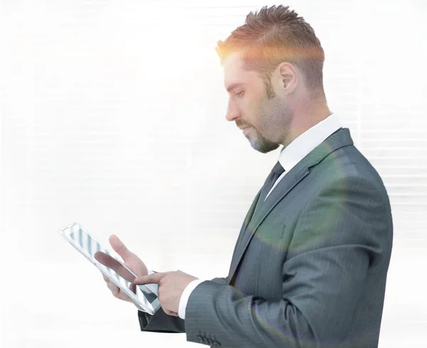 Бизнесмен с планшетным компьютером, стоящим у окна . — стоковое фото