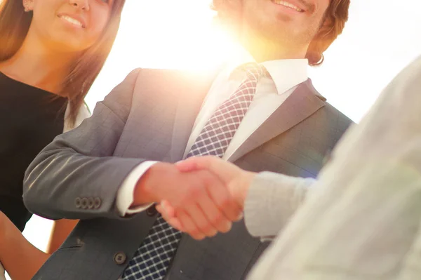 Businesspeople  shaking hands against room with large window loo — Stock Photo, Image