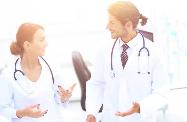 Two Doctors Having Meeting In Hospital Reception Area — Stock Photo, Image