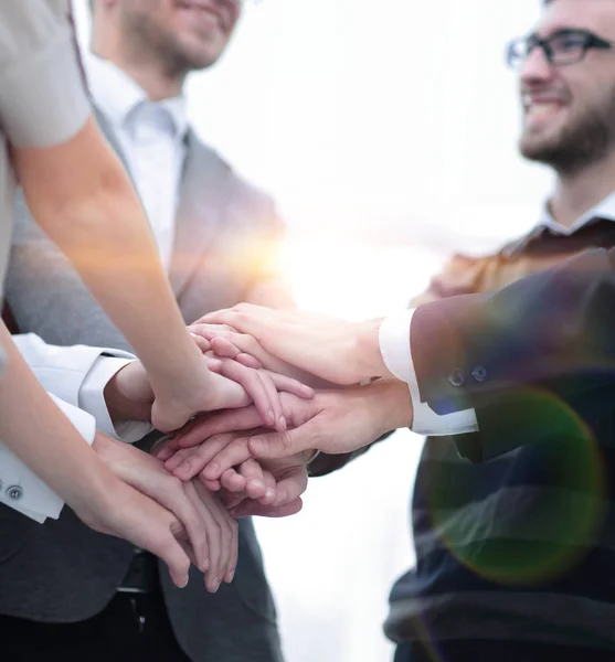 Collega's met hun handen elkaar gestapeld — Stockfoto