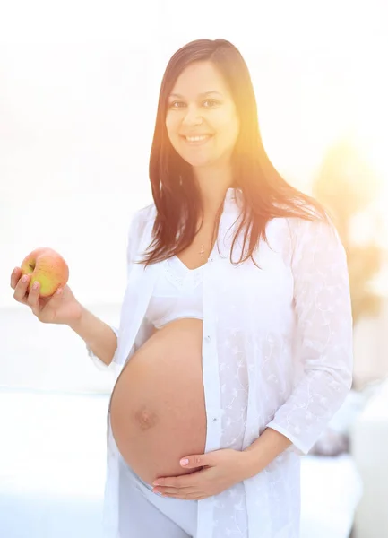 Leende gravid kvinna med ett äpple — Stockfoto