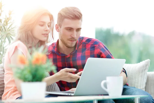 Jonge vrouw toont belangrijke informatie aan haar vriendje op de laptop scherm — Stockfoto