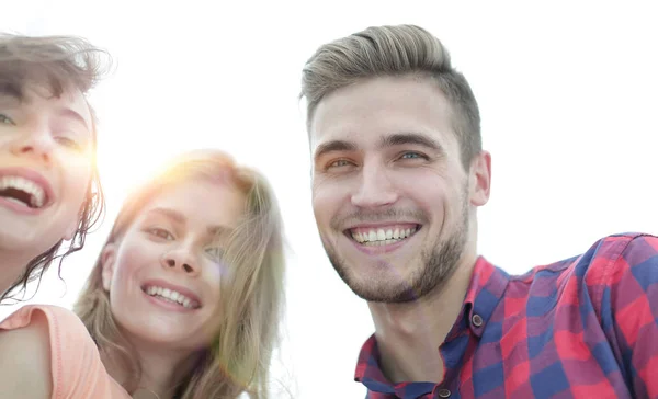 Close-up de três jovens sorrindo em fundo branco — Fotografia de Stock