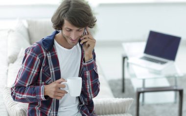 güzel bir fincan adamla bir dizüstü bilgisayar önünde oturur.