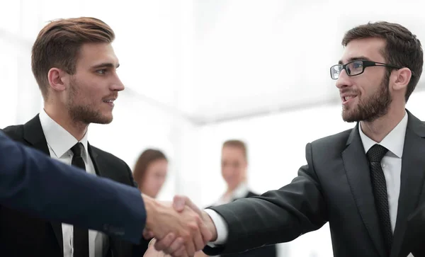 Partners ingår avtal och skakar hand i närvaro av lagmedlemmar — Stockfoto