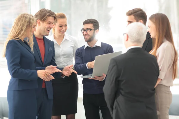 Equipe de negócios bem sucedida discutindo documentos e ideias em pé perto do desktop — Fotografia de Stock