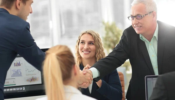 Partner commerciali stringono la mano nella sala conferenze — Foto Stock