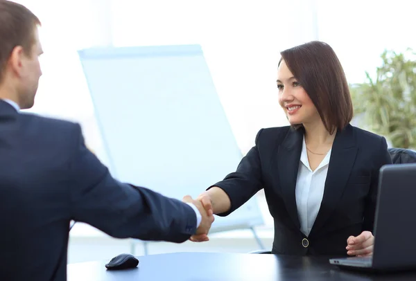 Zakenvrouw schudden handen met een zakenpartner over een bureau — Stockfoto