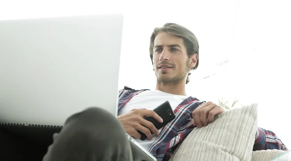 Erfolgreicher Kerl sitzt auf Sofa im Wohnzimmer — Stockfoto