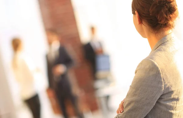 Bakifrån av affärskvinna på suddig bakgrund office. — Stockfoto