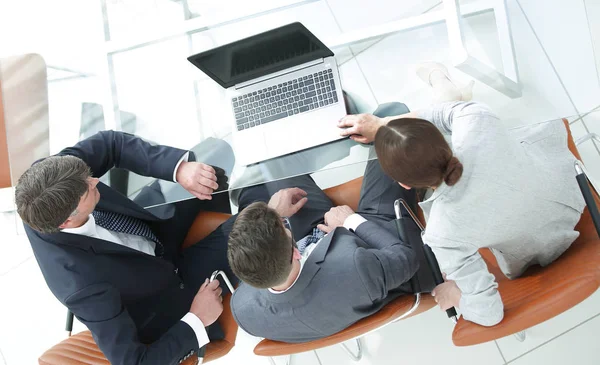 Três pessoas de negócios, reunidas à volta de uma mesa de reuniões — Fotografia de Stock