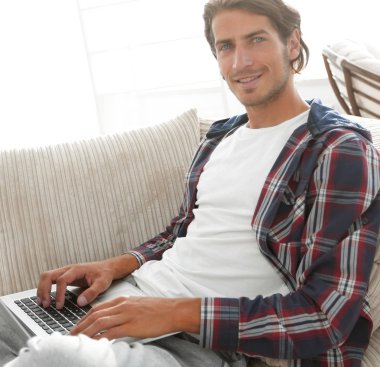 dizüstü bilgisayar ile ciddi genç adam.