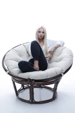 büyük bir rahat tekli koltukta oturan güzel genç kadın.