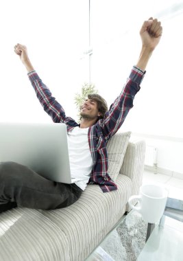 çok mutlu genç adam evde laptop ile çalışma.