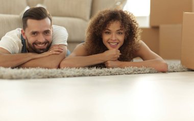 Yeni bir daire arka plan halıya yatan genç Çift