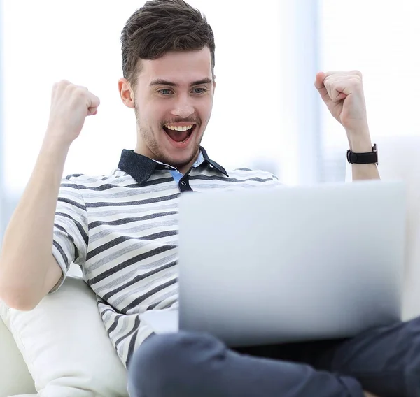 Homem feliz com laptop sentado no sofá — Fotografia de Stock