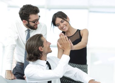 Birbirimizi bir beşlik veren genç iş arkadaşları