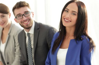 İçinde belgili tanımlık geçmiş meslektaşları ile gülümseyen iş kadını