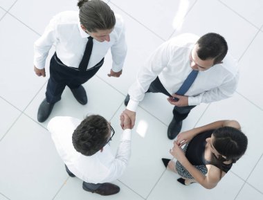 En baştan görüntüleyin. ofis lobisinde tokalaşırken arkadaşları.