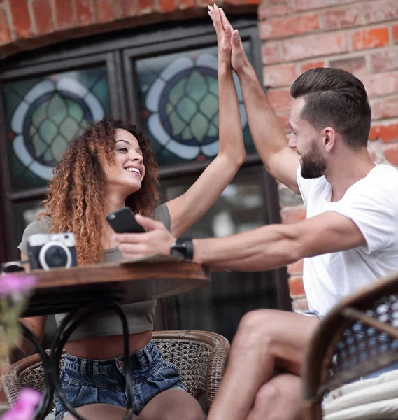 Porträt eines jungen Paares, das sich auf eine Caféterrasse setzt — Stockfoto