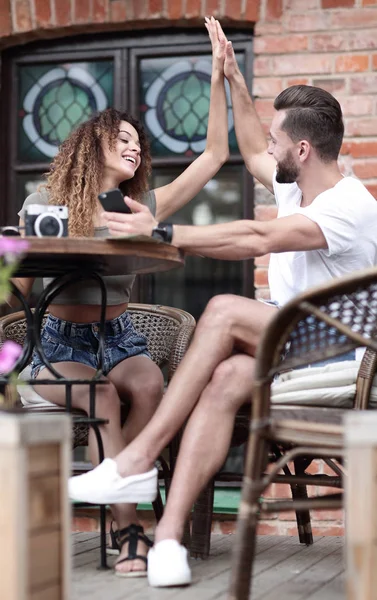 Portret van een jong koppel zitten op het terras van een café — Stockfoto