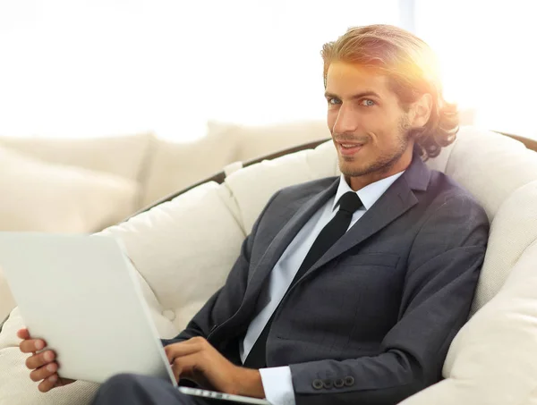 Κοντινό πλάνο του χαμογελώντας επιχειρηματίας που εργάζεται με το laptop στο σαλόνι — Φωτογραφία Αρχείου