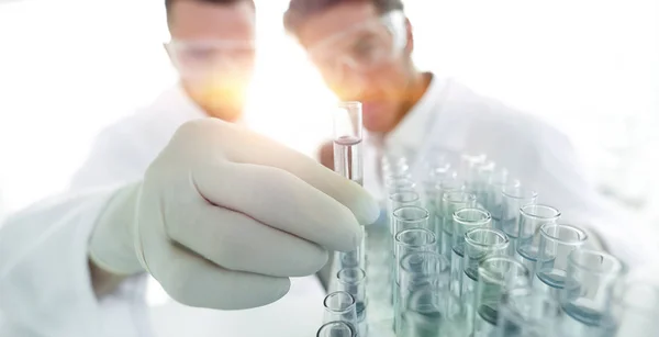 Cientista e assistente estudando a solução no tubo — Fotografia de Stock