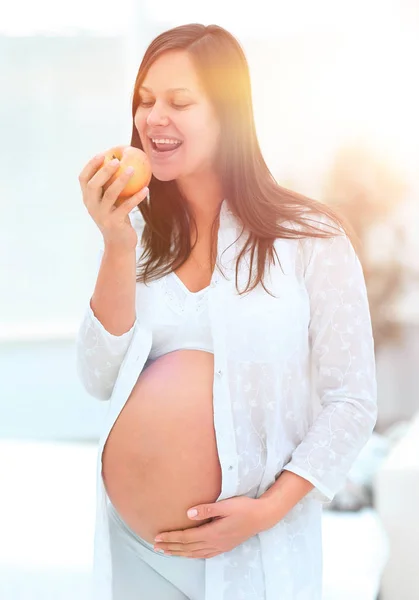 Leende gravid kvinna med ett äpple — Stockfoto