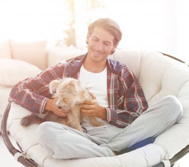 yakışıklı olan büyük bir koltukta oturan bir köpekle.