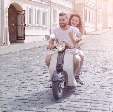 mutlu genç bir çift bir scooter üzerinde eğleniyor