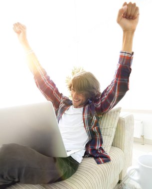 çok mutlu genç adam evde laptop ile çalışma.