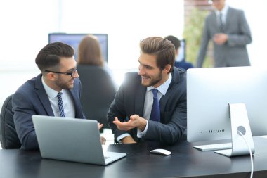 neşeli arkadaşları eğlenmek dizüstü bilgisayarlar ile masa başında oturan