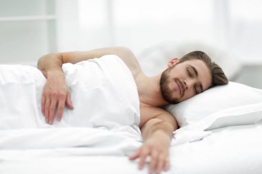 yakışıklı adam yeni yatak odasında yatmak.