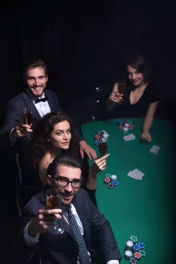 Bir grup genç zengin kumarhanede poker oynuyor.